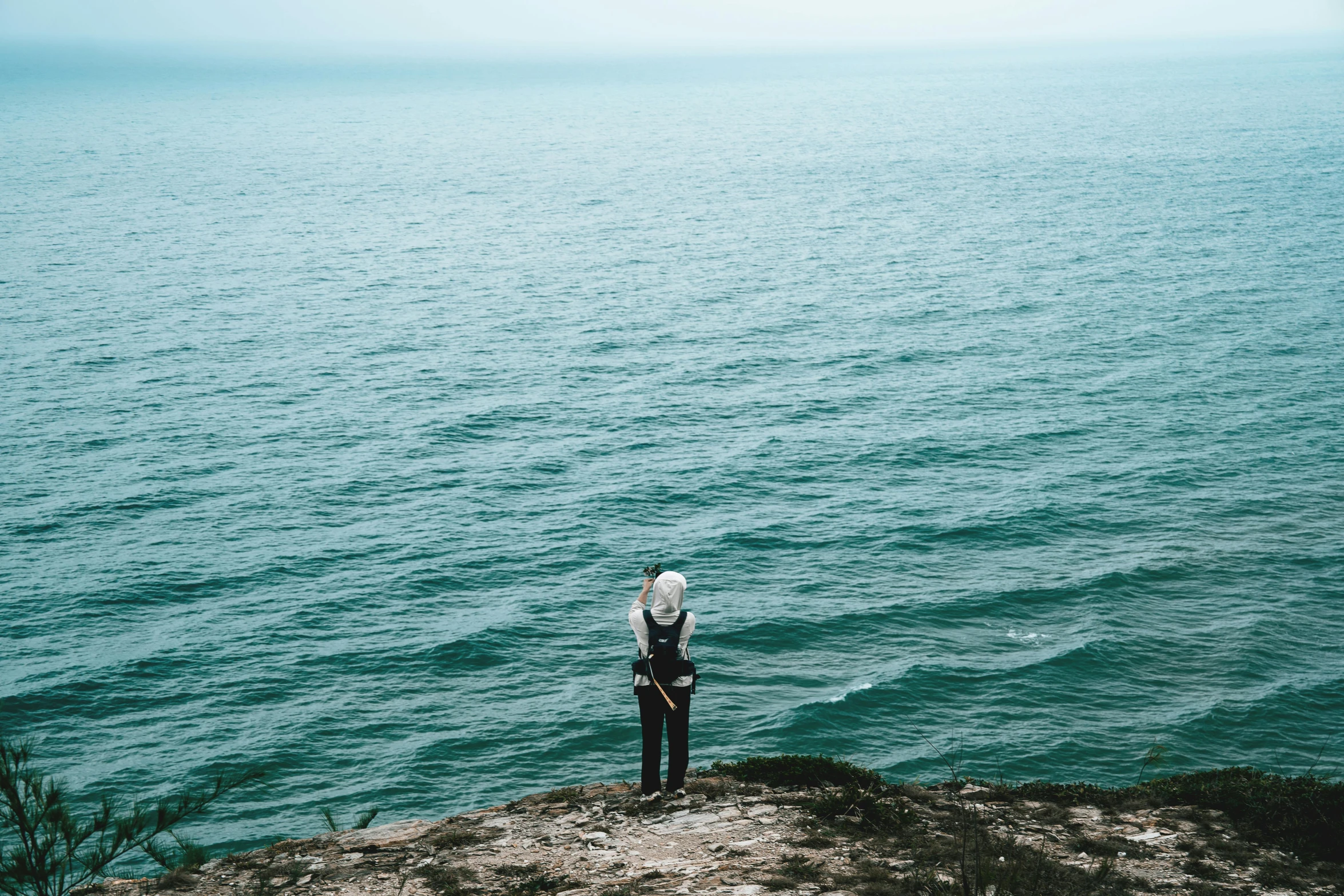 a person standing by the ocean looking at the water