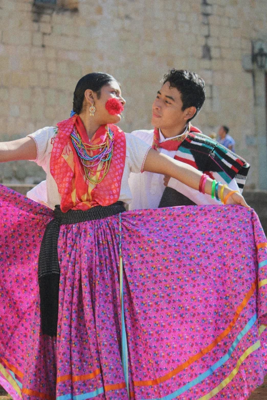 two people in colorful dresses posing for a po