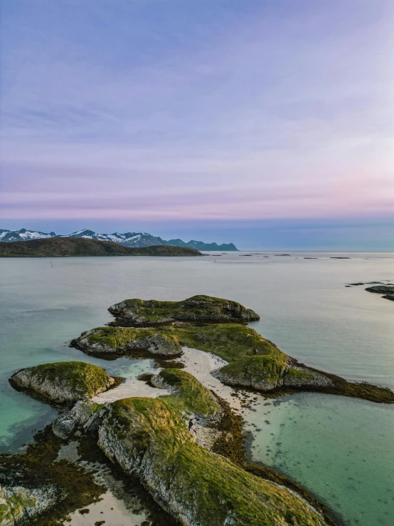 an island on the edge of the ocean near mountains