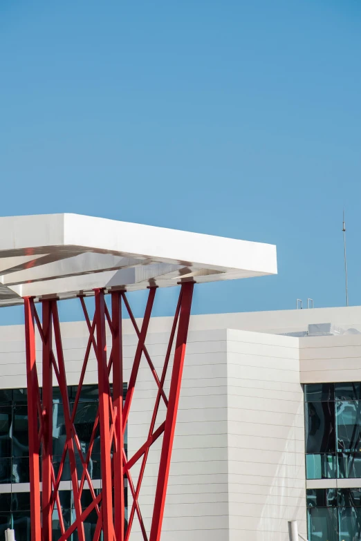 the red metal structure of a white building near a crane