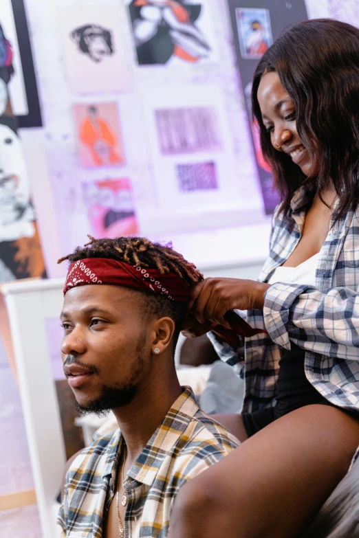 a woman combs the hair of a man in a barbershop