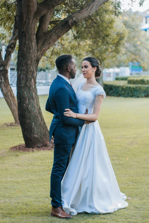 the bride and groom share an intimate moment in the green yard