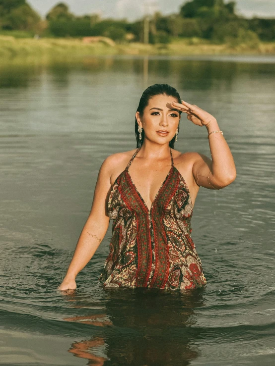 a woman wearing a bathing suit standing in the water