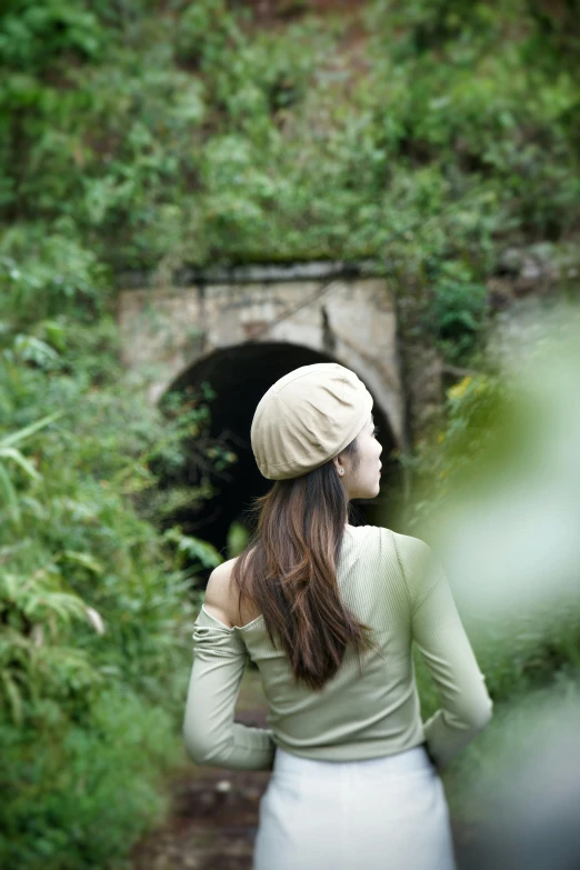 a woman in a turban looks at an outhouse