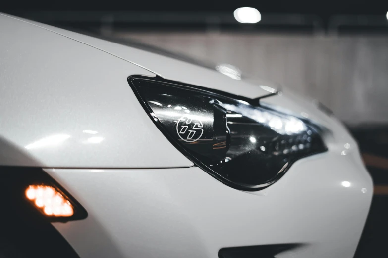 the front lights of a white car in a showroom