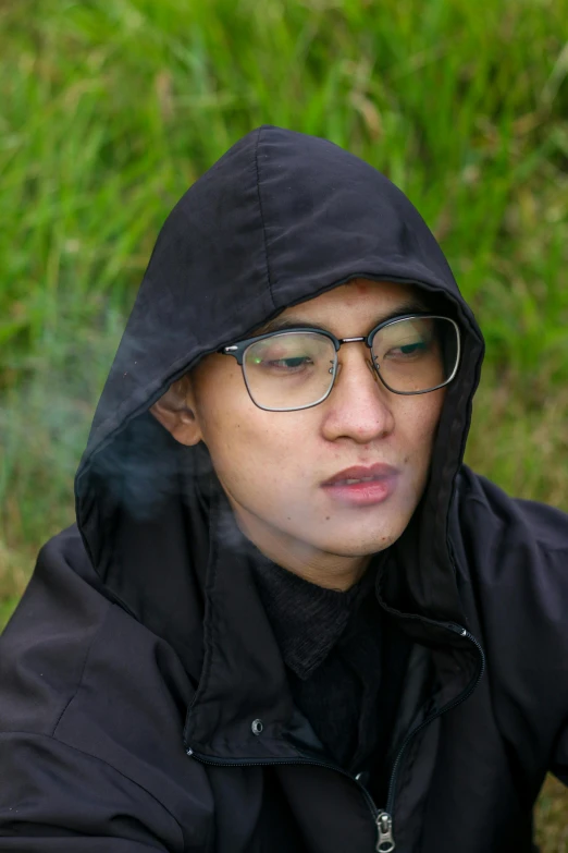 a man wearing glasses with a hooded jacket and black jacket