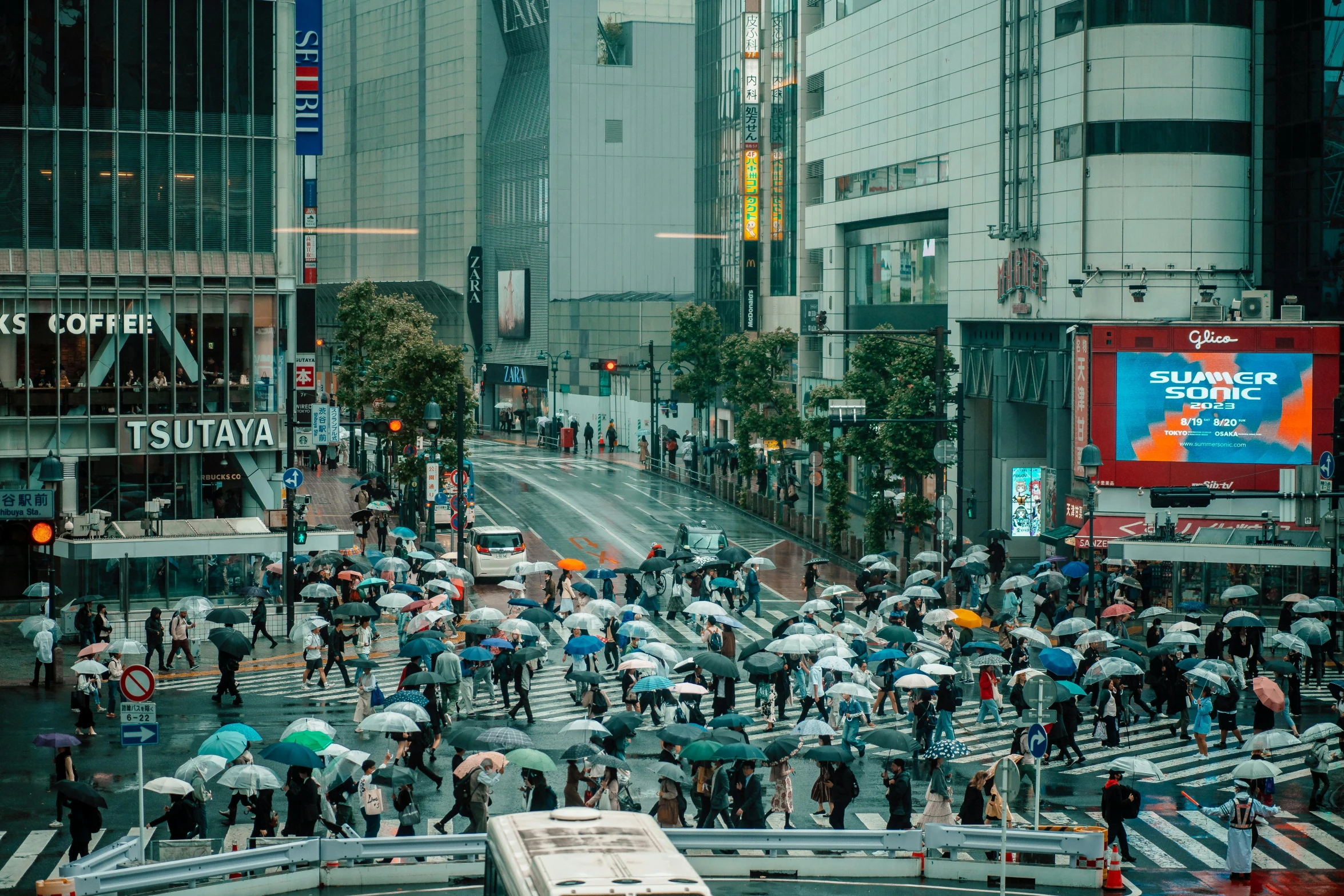 several people are walking and holding umbrellas in the street