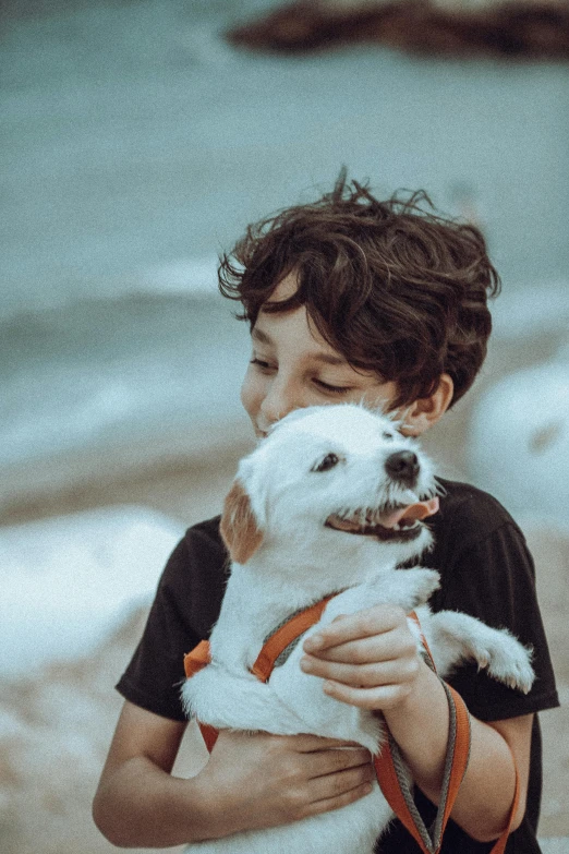 a young child with black and white puppy on leash