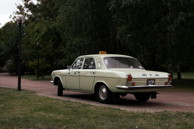 an old fashioned car with the yellow taxi sign on it