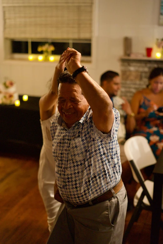 an older man is dancing while his family watches