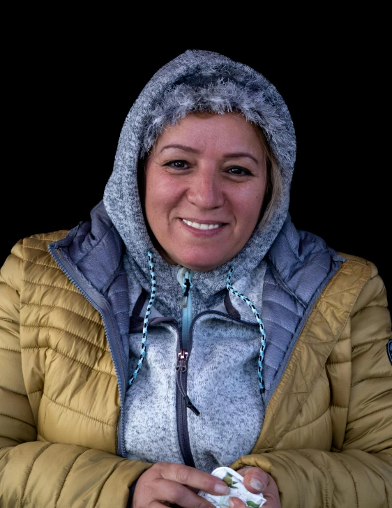 a woman in a yellow jacket with a light blue hood and an ear muffs