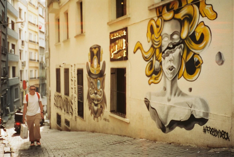 a man and woman with suitcases walk by a mural