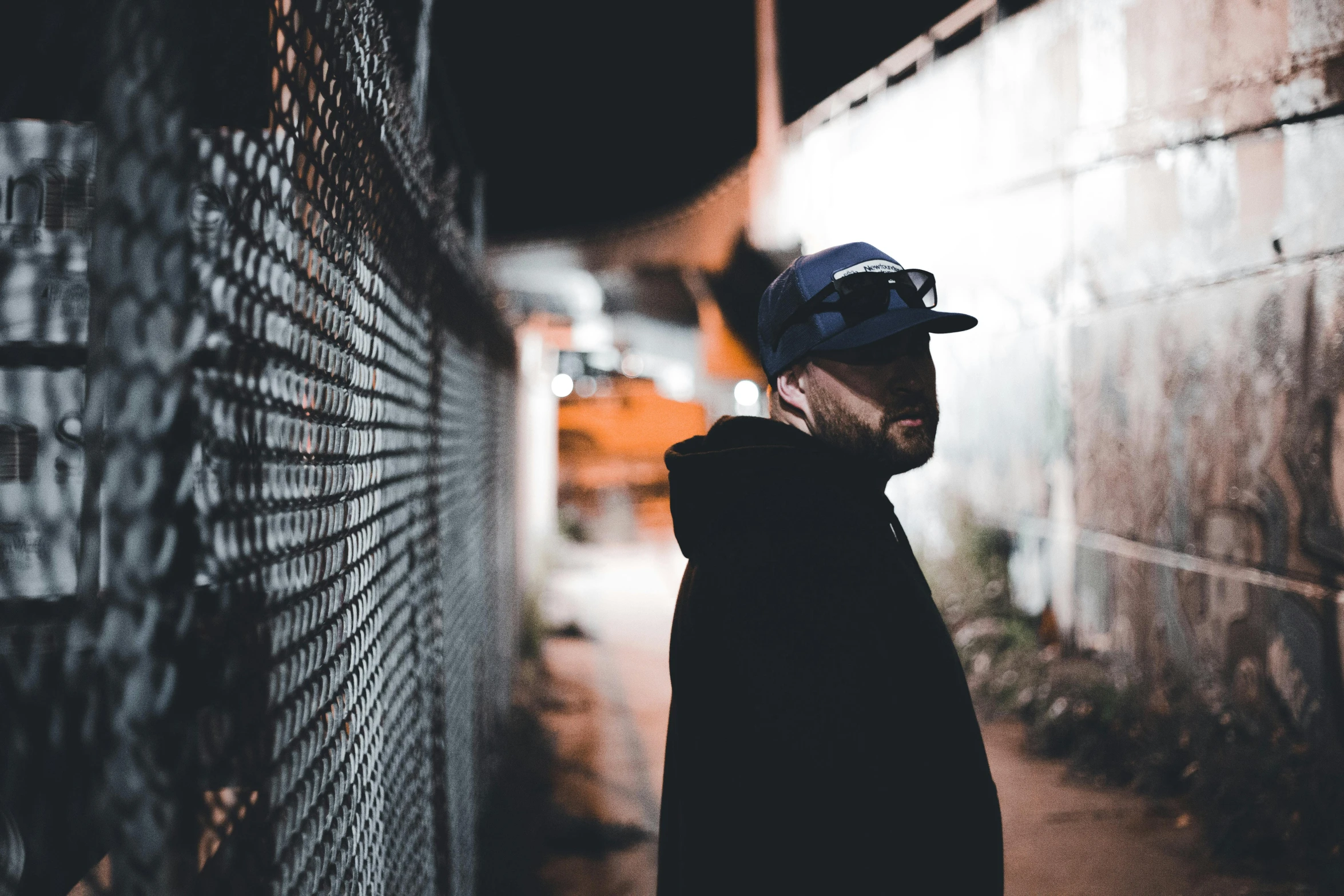 a man is standing outside of a fenced in building