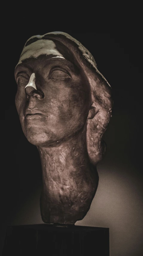 an abstract sculpture of a head wearing a paper hat
