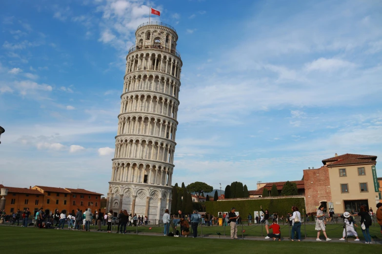 tourists standing around the leaning pisa tower