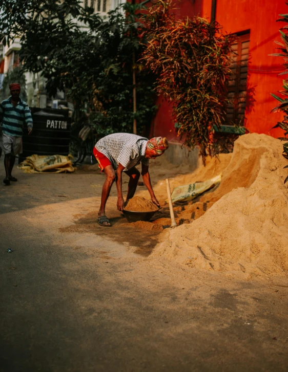 a man with shovels is digging through the sand