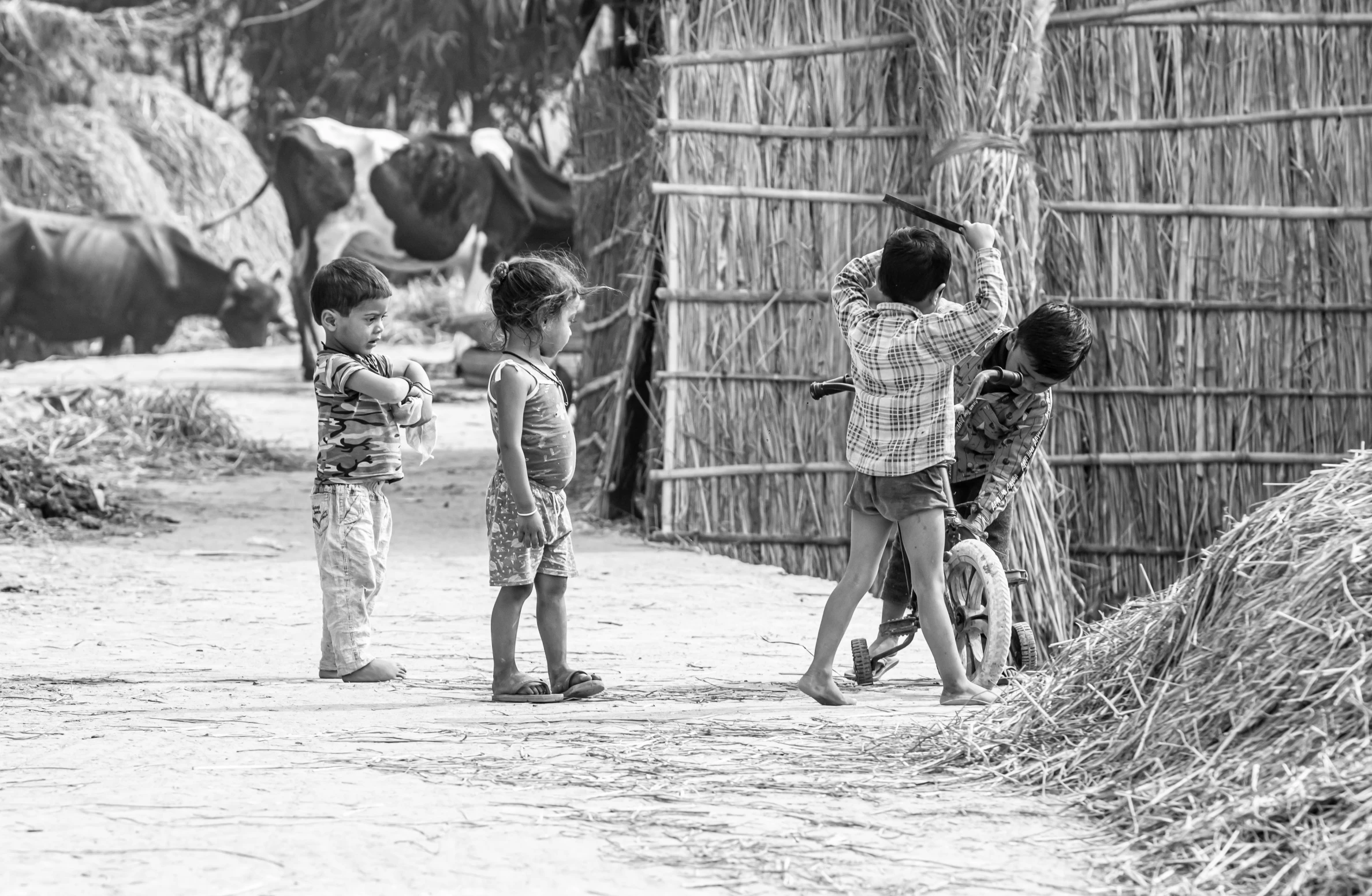 two young children reaching up to reach a toy on a hill