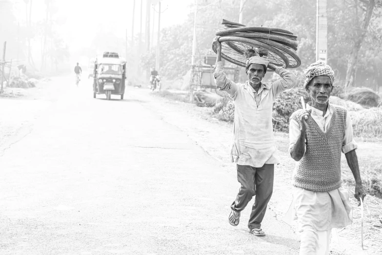 black and white pograph of men carrying baskets over their heads