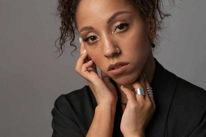 a woman wearing a black shirt has her hand under her face