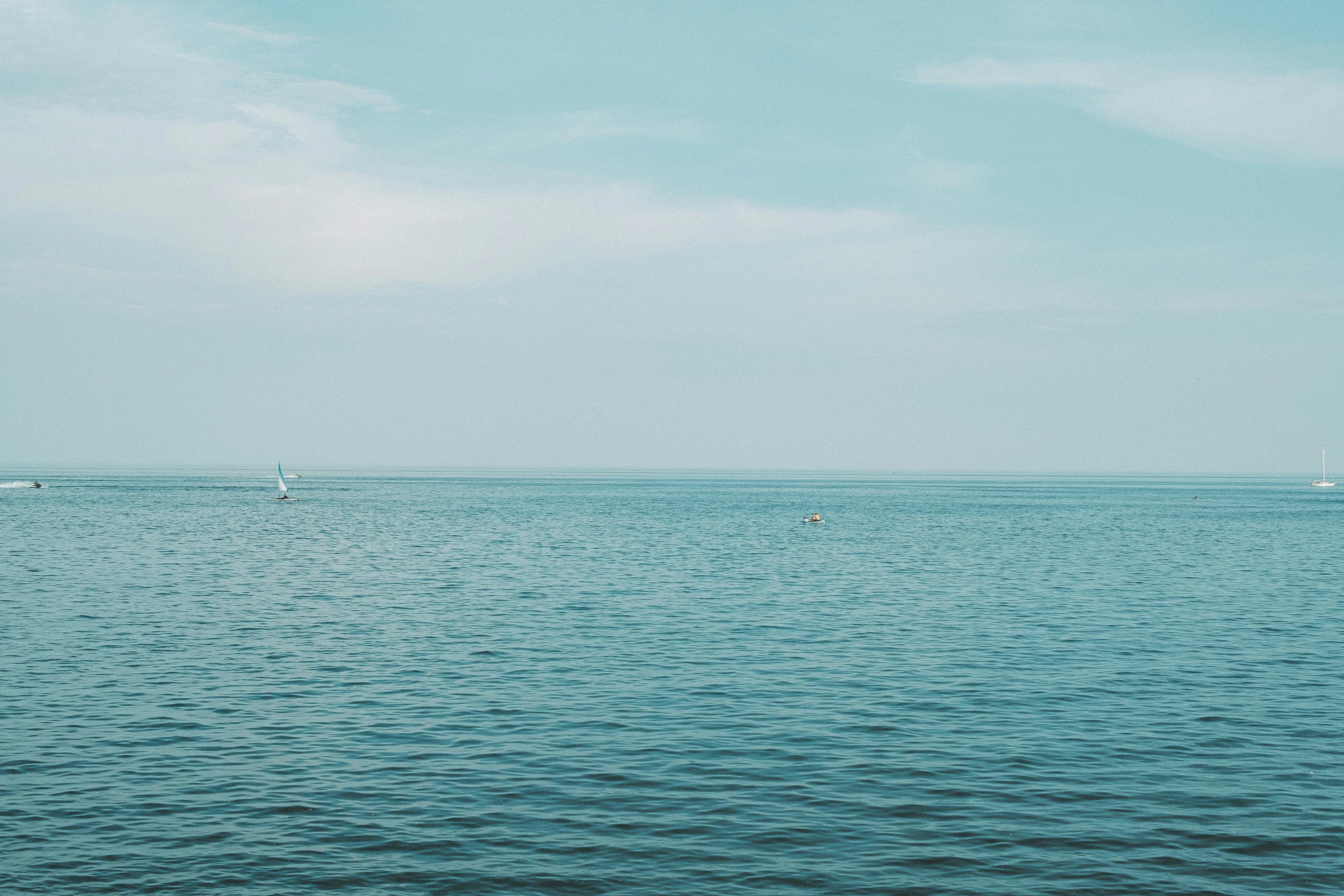 a sailboat sailing in the ocean on a cloudy day