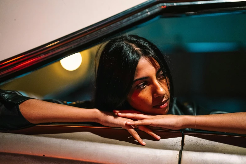 woman in leather shirt leaning on back of car