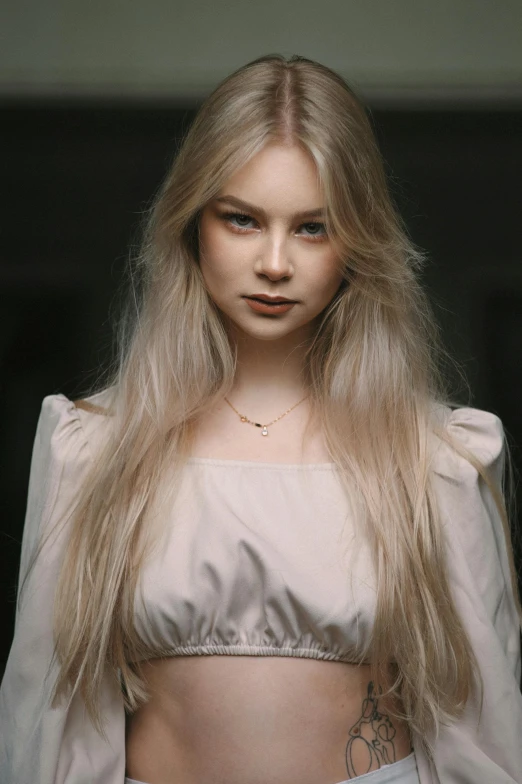 a blonde woman with long hair is posing for a picture