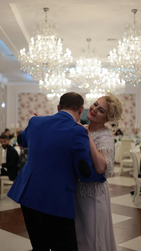 the young couple is dancing in the ballroom