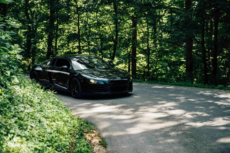 this black car is driving through the woods