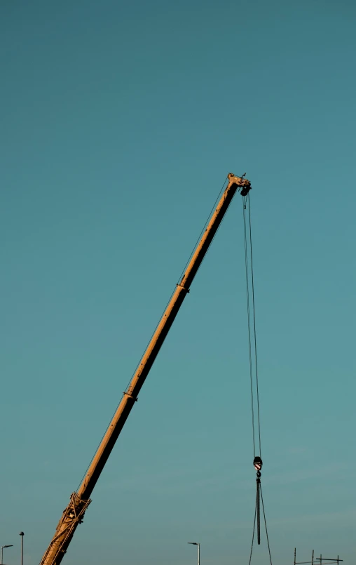 a crane is lifting a pole behind it