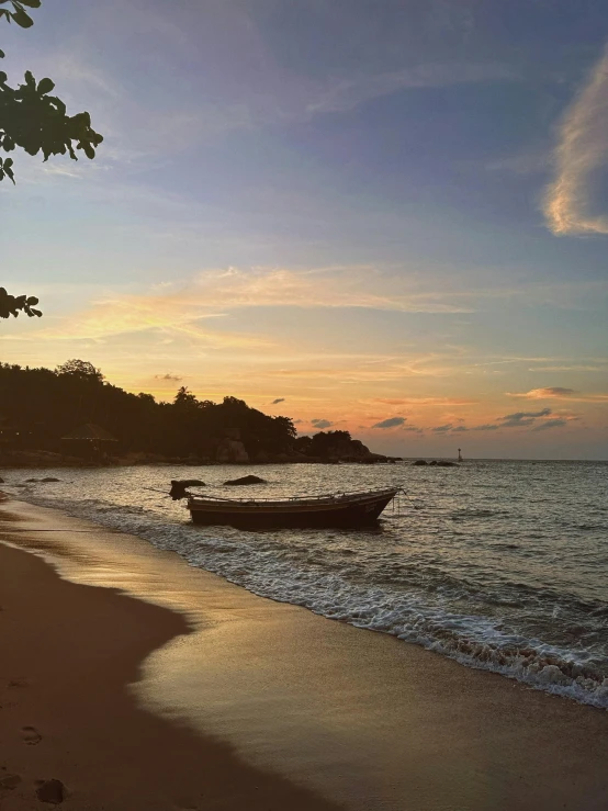 two small boats anchored in shallow water on a beach