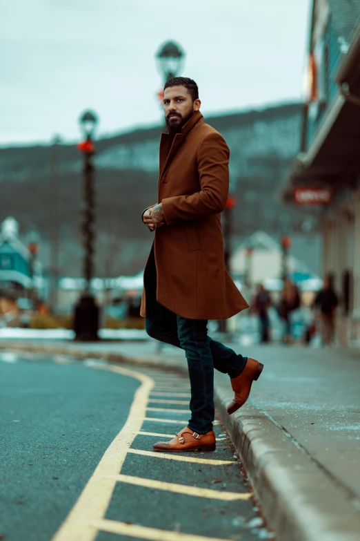 a bearded man leaning on the side of a curb