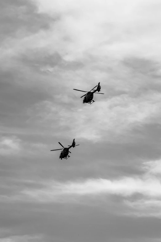 a black and white po of three helicopters flying in the sky