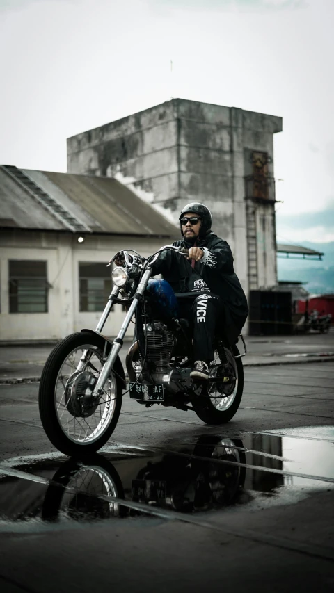 a man wearing black sitting on a black motorcycle