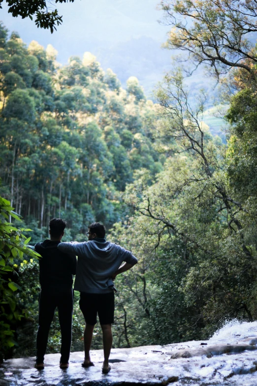 two men stand on the edge of a stream