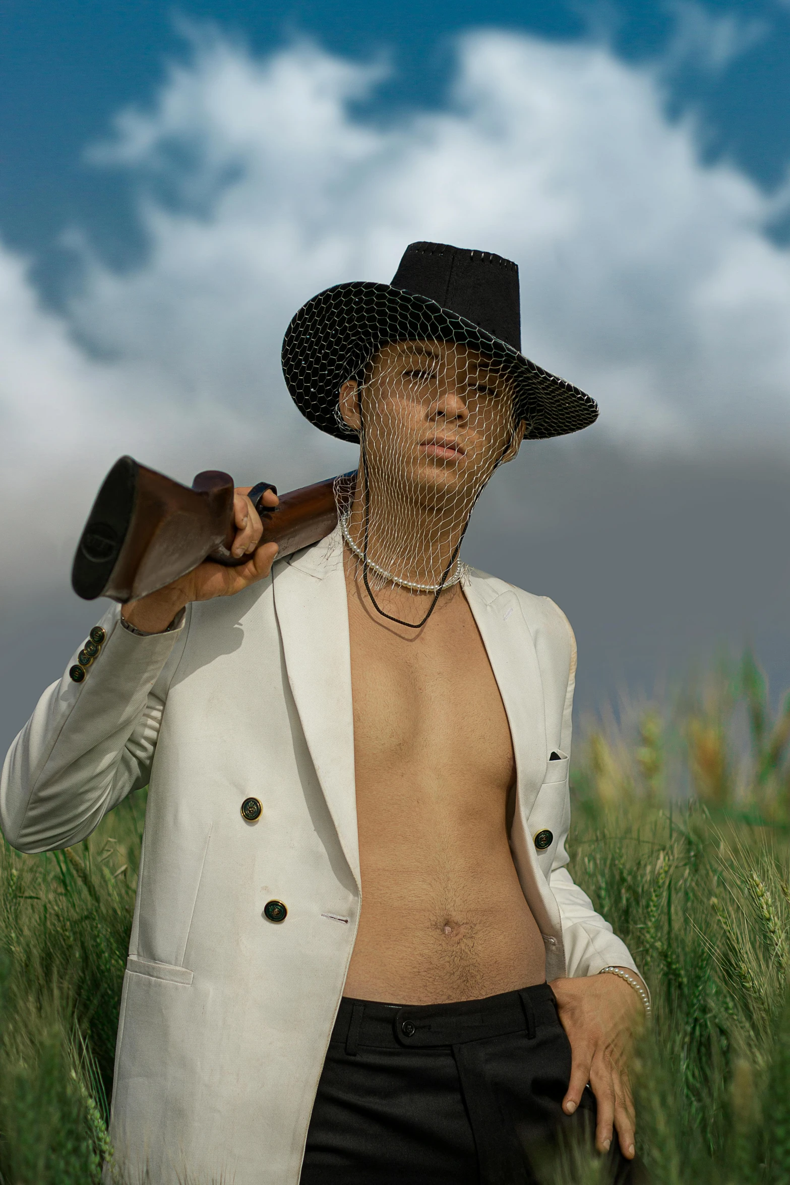 a man in a hat holding a stick and gun