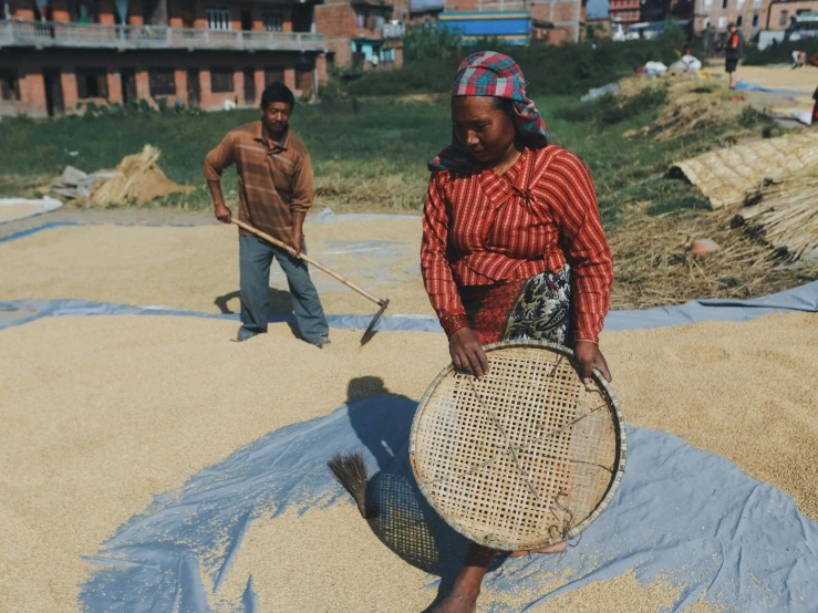 two people standing around holding a basket and a bat