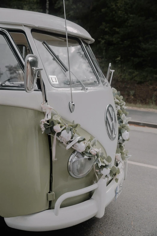 the front view of an old white van decorated with flowers