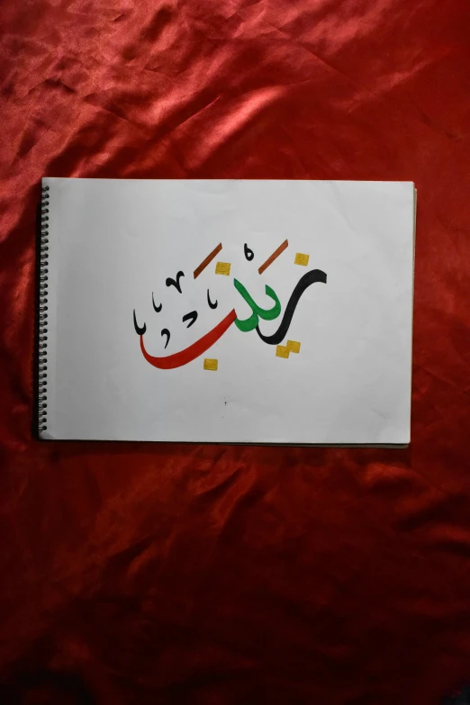 a white sheet with arabic lettering written in multiple colors