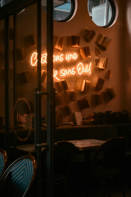 a lit sign in the window in a small restaurant