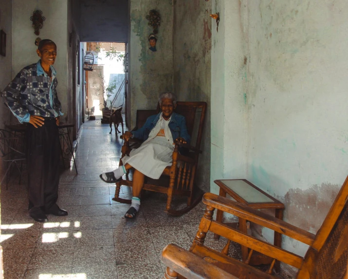 two old people sitting next to each other near a doorway