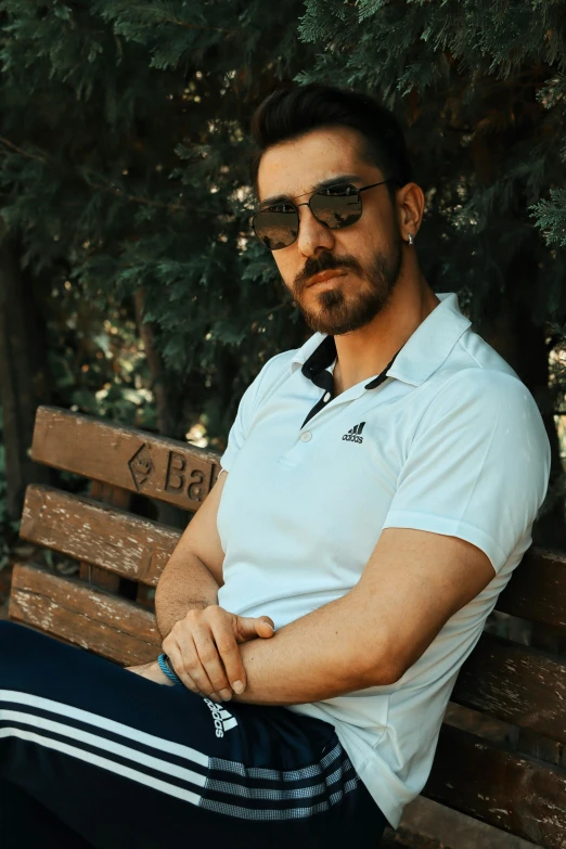 a man sitting on a bench in the shade