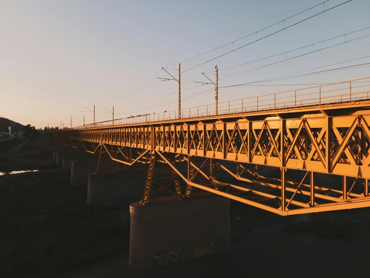 train tracks running across a yellow bridge