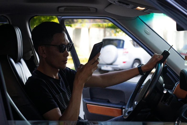 a man driving a car while talking on his cell phone