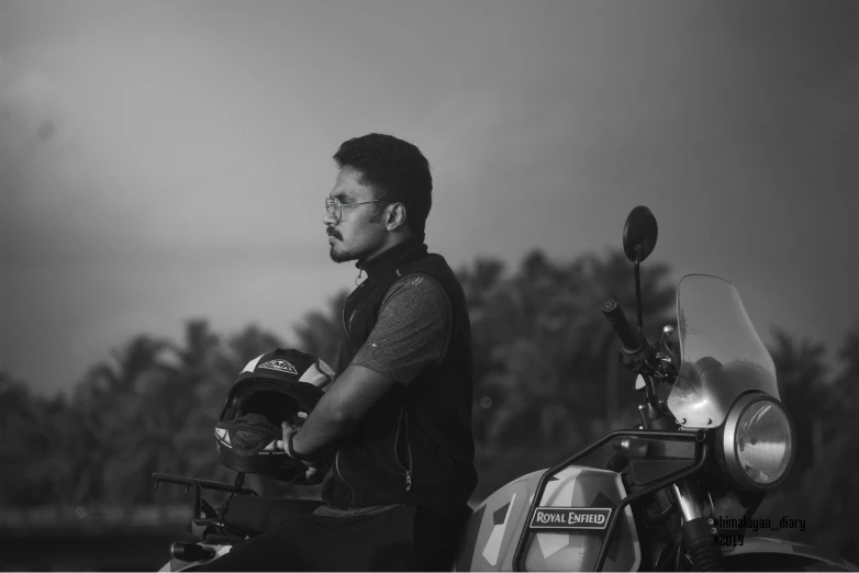 black and white image of man sitting on a motorcycle