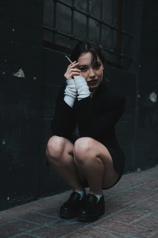 a woman kneeling down on the ground with her hand over her face