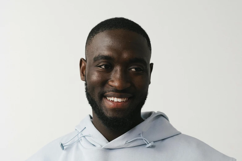 a man wearing a light blue shirt with a hoodie on