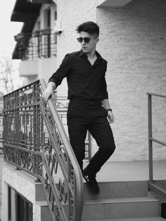 man in black and white po leaning against the railing