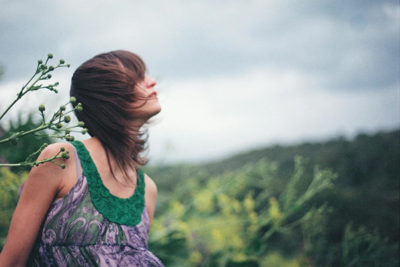 there is a woman wearing a green shirt holding plants