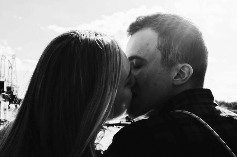 a man kissing a woman from the neck down