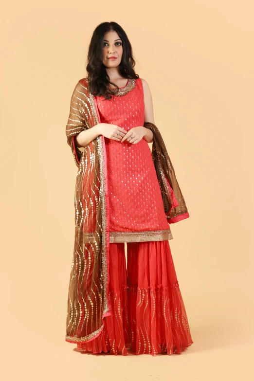 a young woman in red, orange and gold sari outfit